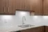 Modern kitchen with elegant wooden cabinetry, sleek granite countertops, and a chic chrome faucet against a stylish white subway tile backsplash.