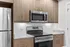 Modern kitchen with sleek stainless steel appliances, elegant wood cabinetry, and granite countertops.