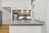 Modern kitchen with sleek granite countertops, stainless steel appliances, and elegant wood cabinetry.
