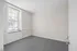 Bright and inviting room with large window, modern carpeting, and sleek minimal design, perfect for personalization.