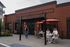 Inviting cafe scene with outdoor seating, red brick exterior, and vibrant umbrellas, creating a lively spot for relaxation and socializing.