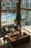 Elegant apartment lounge with floor-to-ceiling windows overlooking a luxurious swimming pool, featuring cozy seating and vibrant plants.