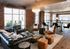 Chic apartment living area with exposed brick, large windows, and elegant furnishings creating a modern and inviting space.