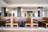 Elegant restaurant interior with modern wooden booths, stylish pendant lighting, and lush greenery accents.