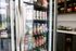 Modern kitchen stocked with a variety of colorful drinks and snacks, featuring sleek refrigerated shelving.