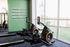 Bright and inviting fitness area with modern rowing machines and motivational quote, 'Life is tough but so are you,' on a vibrant green wall.