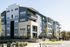 Modern apartment complex featuring contemporary architecture with private balconies, lush landscaping, and spacious walkways.