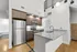 Modern kitchen with stainless steel appliances, granite countertops, and sleek wooden cabinetry, perfect for culinary enthusiasts.