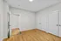 Bright and inviting room with modern design, featuring sleek hardwood floors, minimalistic white walls, and spacious double closets for ample storage.