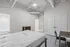 Contemporary bedroom with high ceilings, minimalist design, and en-suite bathroom for a modern living experience.
