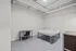 Modern bedroom with a minimalist design, featuring a sleek bed frame, study desk, and chair, highlighting ample space and natural light.