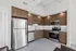 Modern kitchen with sleek stainless steel appliances, elegant wooden cabinetry, and a stylish backsplash, perfect for a contemporary lifestyle.
