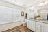 Bright, modern bathroom featuring a sleek granite double vanity, elegant fixtures, and a spacious shower area.
