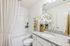 Elegant bathroom with luxurious granite countertop, fresh orchids, and a calming tub area, offering a spa-like retreat.