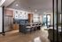 Modern kitchen with spacious island, wooden cabinetry, chic bar stools, and elegant wall art, offering a stylish and inviting atmosphere.