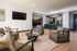 Modern living area with elegant armchairs, sleek coffee table, and stylish wall-mounted TV creating a cozy atmosphere.