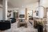 Luxurious living room with modern fireplace, plush seating, and elegant decor in a sunlit open-concept space.