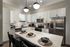 Modern kitchen with sleek appliances, spacious island, and stylish pendant lighting, perfect for entertaining.