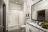 Elegant bathroom with a sleek vanity, modern fixtures, and stylish decor, featuring a bathtub with white subway tiles and a spacious mirror.