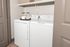 Modern laundry room featuring a sleek washer and dryer with convenient storage shelf, perfect for streamlined living.