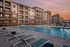 Chic apartment complex showcasing a resort-style pool area with inviting lounge chairs at sunset.