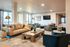 Luxurious and spacious living room featuring modern seating, elegant art, and large windows for natural light.