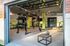 Modern fitness center with TRX equipment, kettlebells, and open garage doors for a refreshing workout environment.