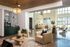 Modern open-concept living area with elegant furnishings, stone accent wall, and abundant natural light, ideal for stylish gatherings.