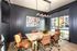 Chic and modern conference room with leather chairs, elegant wood table, and artistic decor, bathed in natural light from large windows.