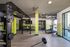 Modern fitness center featuring advanced TRX training setup, treadmill, weights, and vibrant decor perfect for any workout enthusiast.