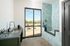 Contemporary pet washing station with stylish blue tiles, alongside a sleek kitchen area and large glass doors opening to an inviting patio.