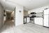 Contemporary kitchen with sleek stainless steel appliances, chic white cabinetry, and elegant hardwood flooring.