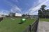 Charming residential community showcasing modern homes with beautiful landscaping and a vibrant playground under a clear blue sky.