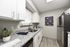 Bright, modern kitchen with sleek granite countertops, white cabinetry, and stainless steel appliances. Inviting space for culinary creations.