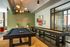 Modern game room with a sleek pool table, shuffleboard, and stylish decor, creating a vibrant social space.
