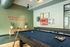 Chic game room with pool tables, vibrant artwork, and playful decor offering endless fun.