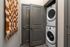 Modern apartment featuring a convenient in-unit stacked washer and dryer, elegantly hidden behind sleek gray double doors.
