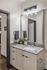Modern bathroom showcasing a sleek granite countertop, stylish lighting, and tasteful decor for a sophisticated ambiance.