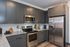 Modern kitchen with sleek dark cabinets, stainless steel appliances, and granite countertops, offering a stylish and functional culinary space.