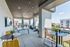 Charming covered rooftop terrace with stylish seating, ping pong table, and string lights offering a scenic city view.