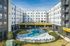 Modern apartment complex featuring a beautifully designed outdoor pool area surrounded by lush landscaping and stylish architecture.
