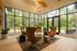 Inviting lounge area with modern armchairs, large windows showcasing lush greenery, and contemporary lighting creating a cozy atmosphere.