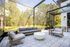 Luxurious outdoor living area with chic patio furniture and a beautifully landscaped garden view, offering a serene, nature-filled retreat.