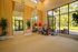 Spacious home gym with vibrant natural light, featuring modern fitness equipment and a serene outdoor view.