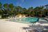 Inviting outdoor pool area with vibrant yellow umbrellas, surrounded by lush greenery, offering a serene escape for relaxation.