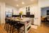 Elegant kitchen with modern appliances, granite countertops, and cozy breakfast bar seating in a spacious open floor plan.