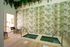 Serene indoor spa area with twin plunge pools, lush green botanical wall decor, and comfortable seating, creating a relaxing oasis vibe.