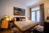 Inviting bedroom featuring a cozy bed with stylish pillows, warm lighting, and elegant decor, perfect for relaxation.