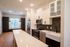 Modern kitchen with sleek white cabinets, stainless steel appliances, and a spacious island for dining and entertaining.