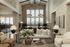 Chic living area with vaulted ceilings, stone accent wall, and plush seating, bathed in natural light from large windows.